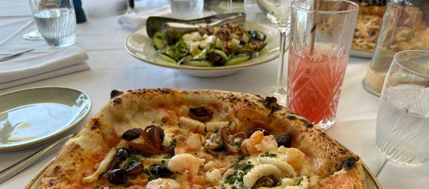 Il Piatto - Pizza with a drink on dining table
