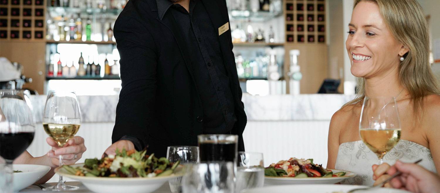 Il Piatto - Waiter serving dinner to guests at dining table