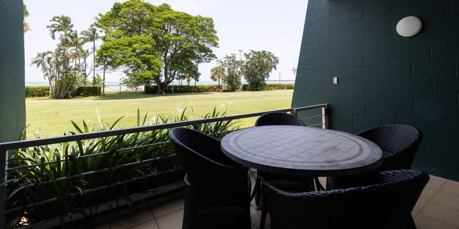 Chairs and table on an enclosed patio facing the Mindil property.