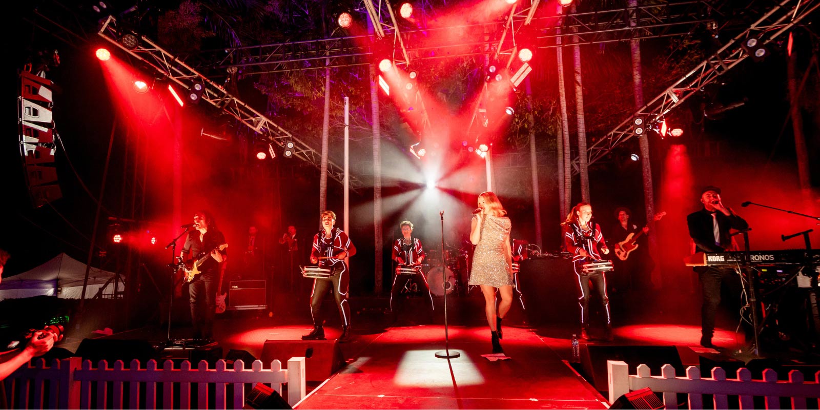 Band performing on stage with red stage lights at Mindil Beach