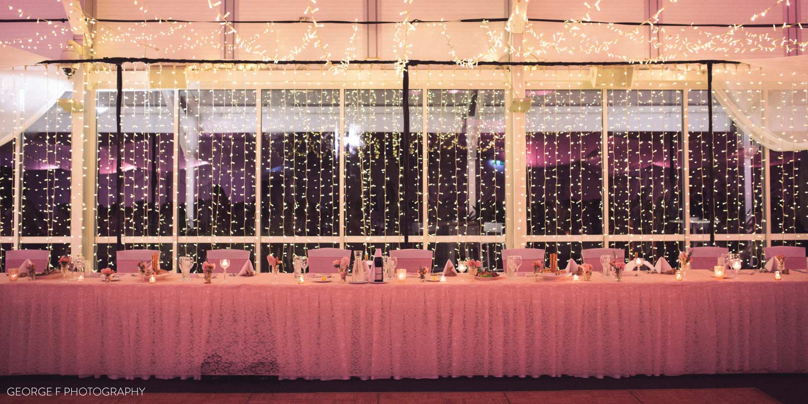 The head table at a wedding reception at Mindil Beach featuring string lights