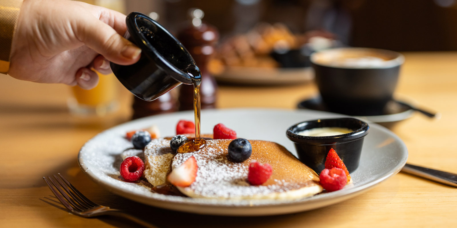 Pancakes with syrup being poured