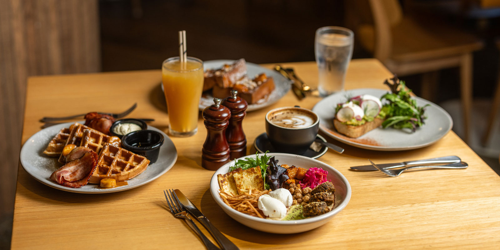 A table set for four featuring breakfast and lunch foods