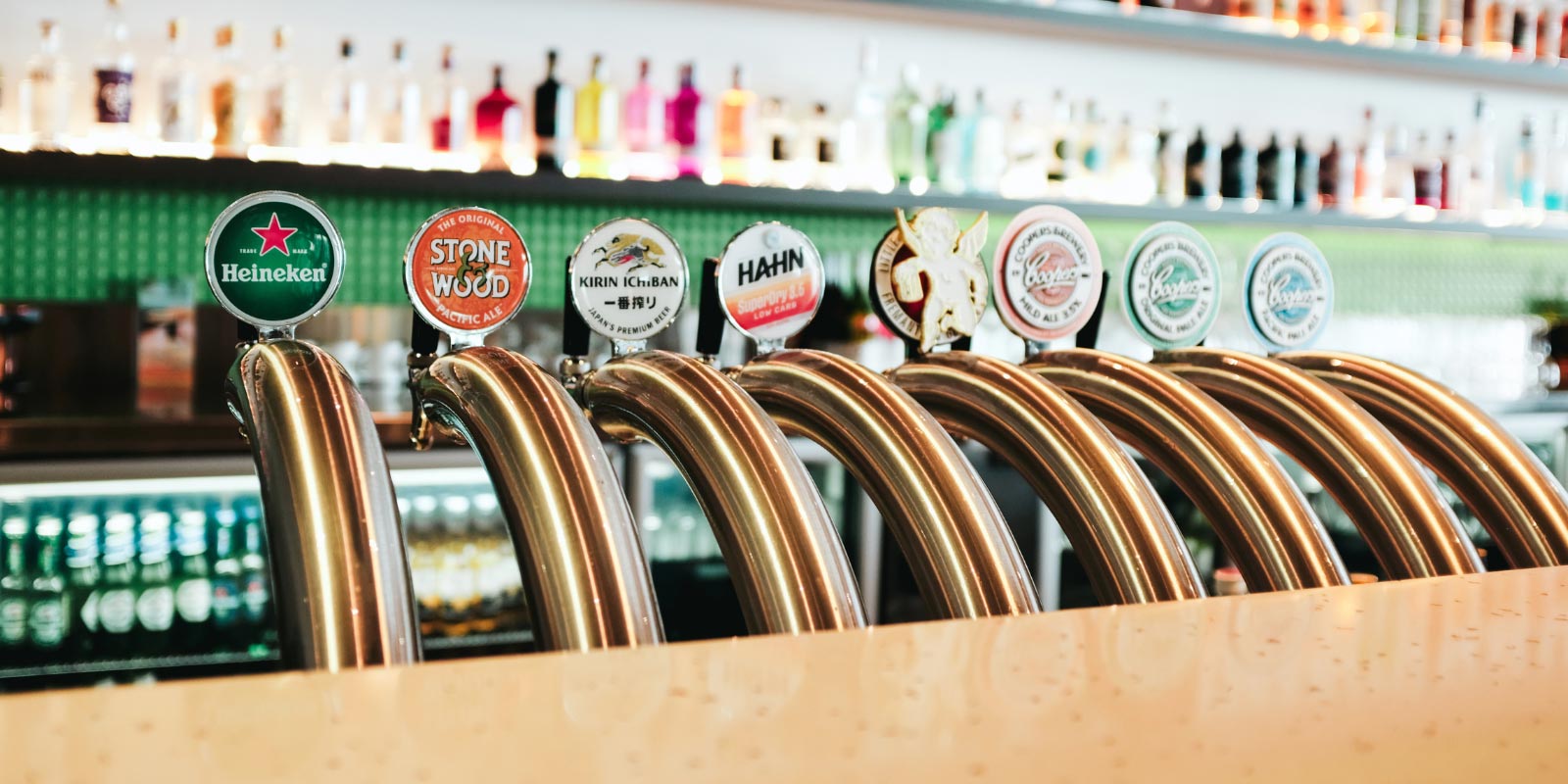 Shot of beer logos that are on tap behind the bar.