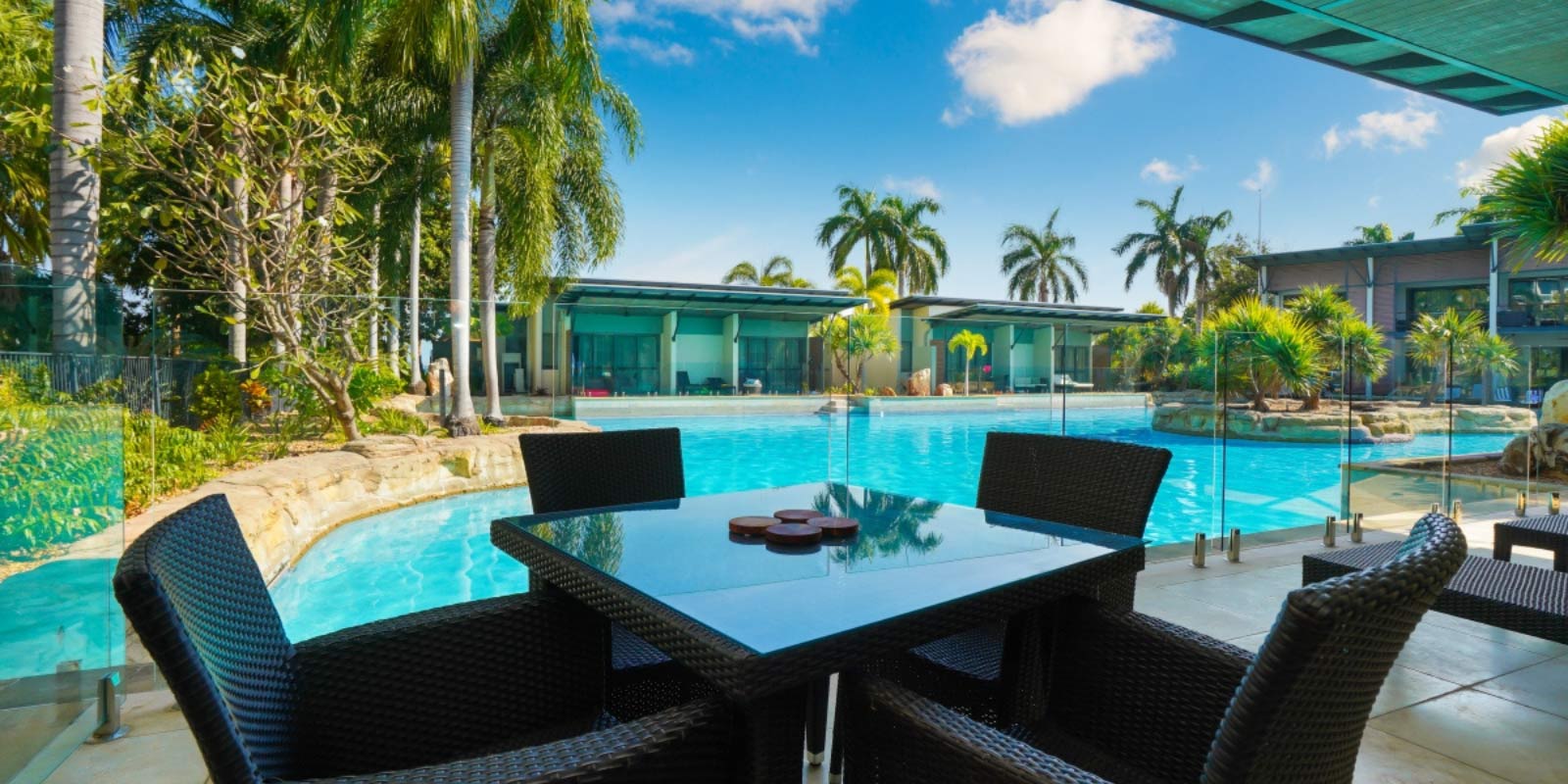 View of the blue pool with patio table and chairs next to it