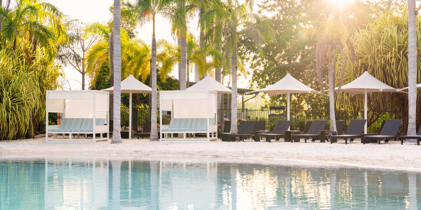 View of a sandy beachfront with tents, patio chairs and umbrellas