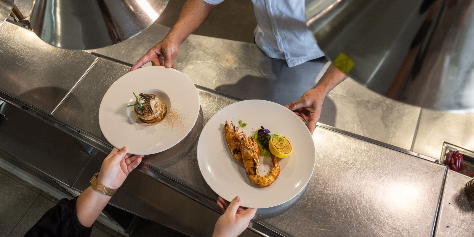 Dinners being passed from Chef to Server at il Piatto