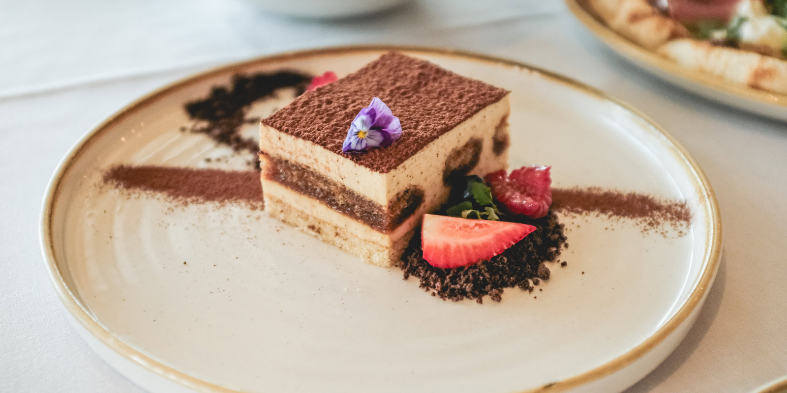 A platted dessert with floral decorations.